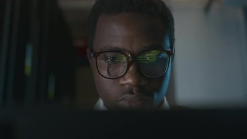 Young Adult with Glasses Looking at Computer Screen