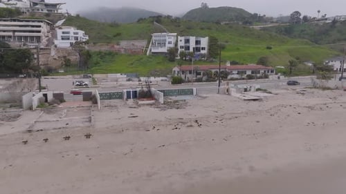 Aerial pull-back burn-down shot over Malibu coastline
