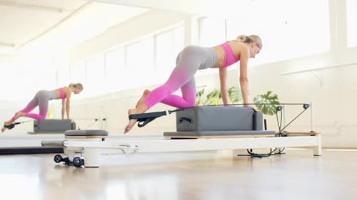 Blonde Woman Doing Pilates Exercises on Machine