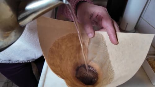 Pouring Water into Coffee Filter in Kitchen