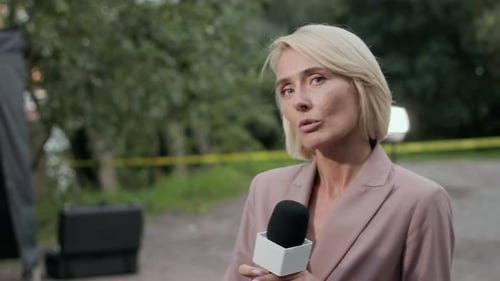 Blonde Woman Reporting News Outdoors with Microphone