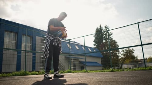 Young Man Bouncing Volleyball Outdoors in Sports Arena
