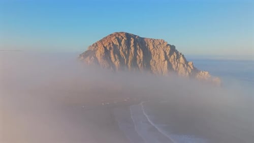 A Majestic Coastal Rock Formation Shrouded in Sea Fog During a Beautiful Sunrise