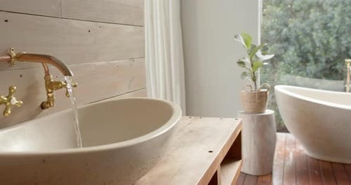 Close up of washbasin with running water in bathroom, slow motion
