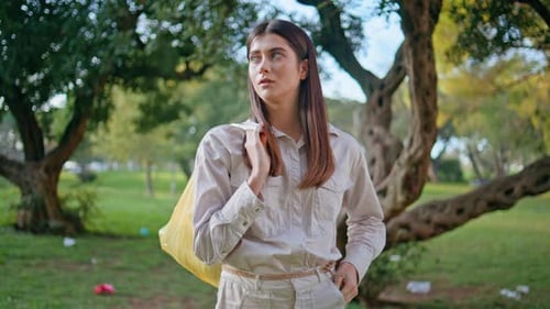 Voluntaria ecológica que lleva una bolsa de basura en Parkland acerca de una mujer de cerca después de una limpieza activa