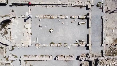 Prise de vue aérienne par Drone en zoom arrière depuis un temple grec révélant l'ensemble du site au bord de la mer.