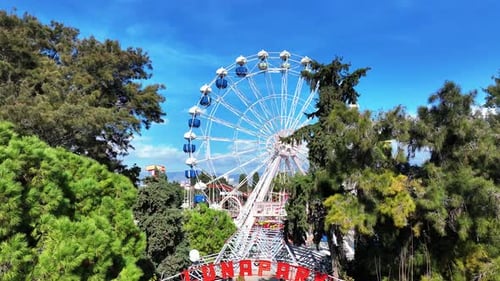 Aerial shot of the Ferris wheel in the amusement park with a drone