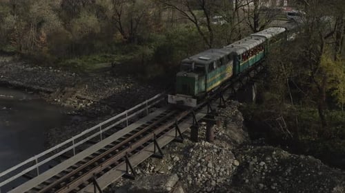 Aerial View of a Train Traveling Over a Railway Bridge Over a River