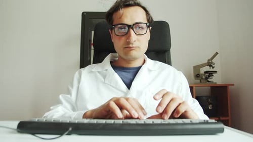 Scientist Typing at Computer in Lab