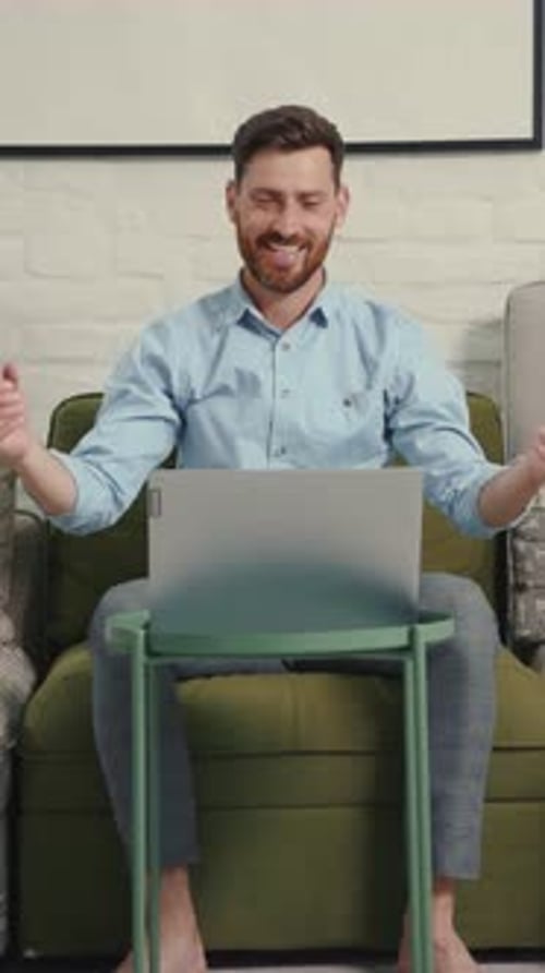 A Man Relaxes on a Couch Engaged with His Laptop Embodying Comfort