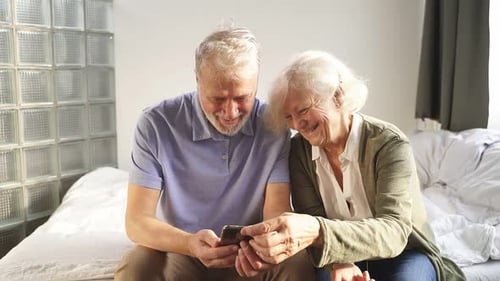 Senior Couple Enjoying Mobile Phone at Home