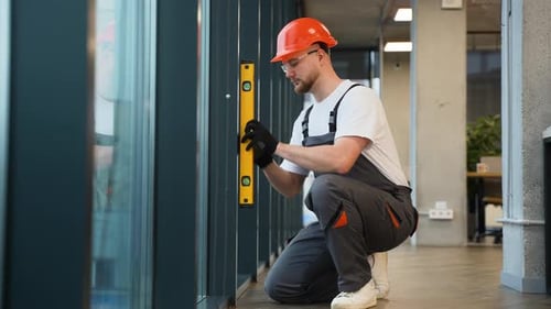 Construction Worker Using Spirit Level on Window Frame