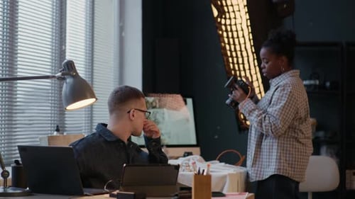 Photographer Adjusting Settings with Model in Studio