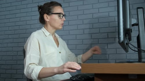 Woman Using Inhaler at Desk in Workplace