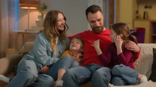 Happy Family Smiling Together on Living Room Couch