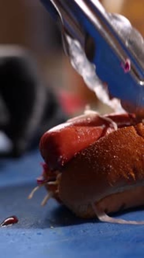 A chef prepares delicious hot dogs in a restaurant.