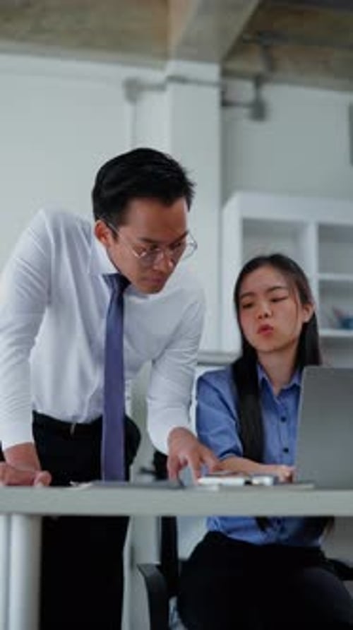 Office Colleagues Discussing Work at a Laptop