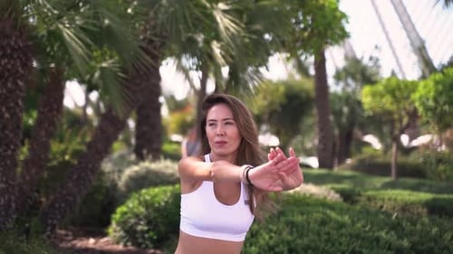 Woman Stretching Arms in a Tropical Park