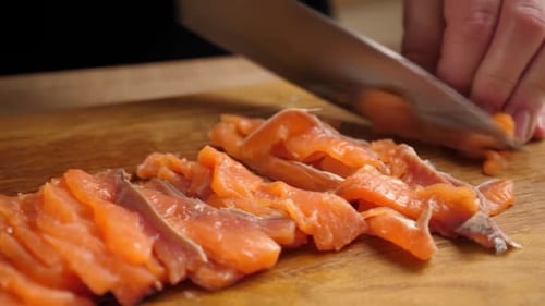 Cutting Raw Salmon on Wooden Cutting Board