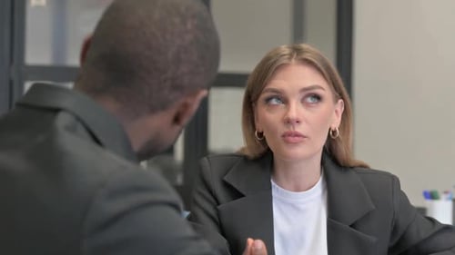 Nahaufnahme einer Geschäftsfrau, die mit einem Teamkollegen im Büro spricht