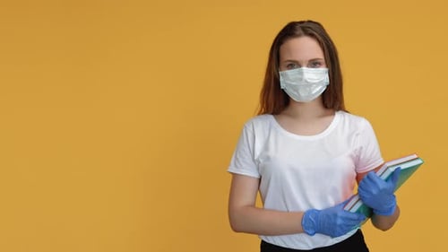 Woman Wearing Mask and Gloves Holding Books