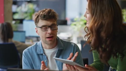 Cheerful Coworkers Discussing a Tablet in the Office