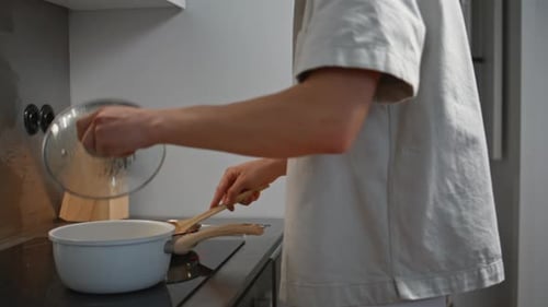 Adult Cooking Delicious Sauce in Modern Kitchen