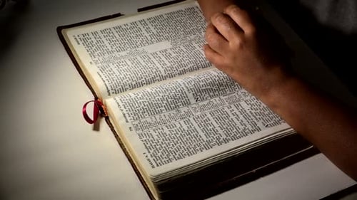 Bird's eye view of African American woman praying over open bible