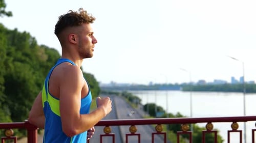 Handsome Young Man Running Across the Bridge Early in the Morning Urban Workout Cardio Exercise