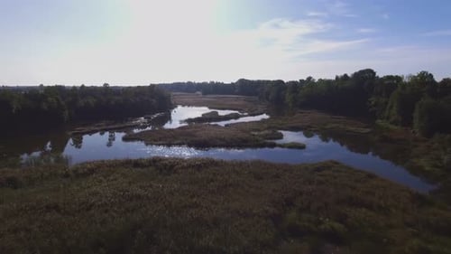 Flying Low Backwards Over The Winding River on a Sunny Morning.