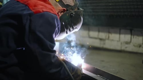 Welder Working with Metal and Sparks