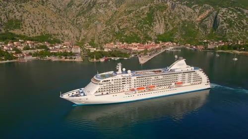 The Drone Captures a Stunning Aerial View of a White Cruise Ship Leaving the BokaKotor Bay in