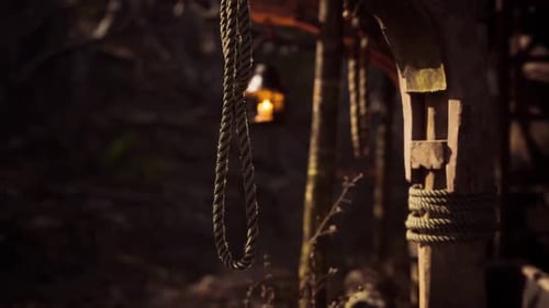 Rustic Lantern and Ropes Hang in a Dimly Lit Wooden Structure at Dusk