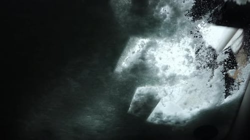 Girl Cleaning Frozen Windshield Of A Car From Snow - close up