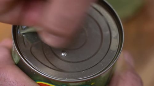Male Hands Pulling Open A Can Of Strawberries Close Up In Slow Motion