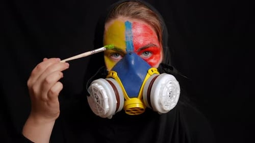 Woman in Mask Painting Face with Brush
