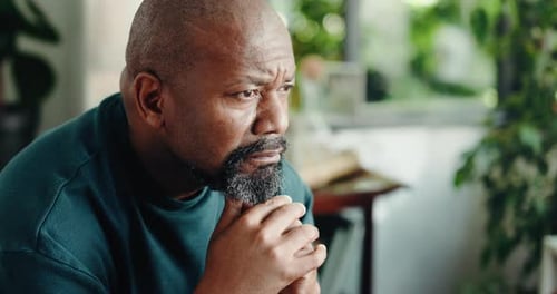 Contemplative man in living room deep in thought
