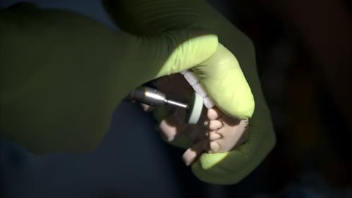 Dentist Using Drill on Teeth Mold in Close Up