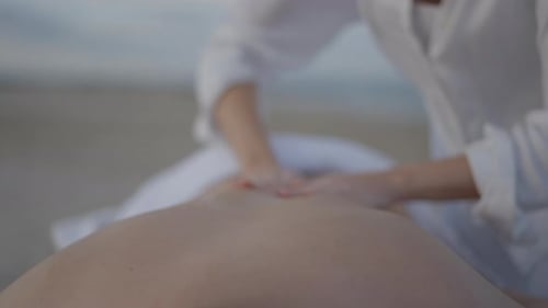 Unrecognizable Man Gets Relaxing Back Massage at the Beach