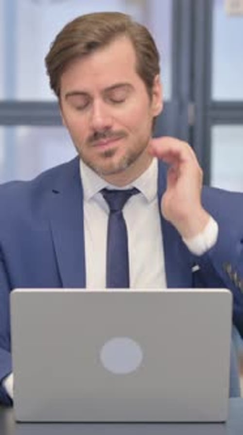 Business Man at Laptop Massaging Stiff Neck