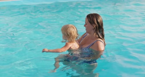 Mutter mit ihrem Sohn amüsiert sich im Schwimmbad
