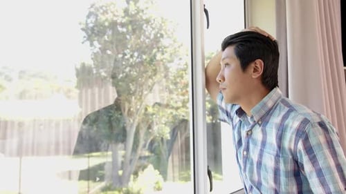 Man Looking Out Window Intently During Daytime