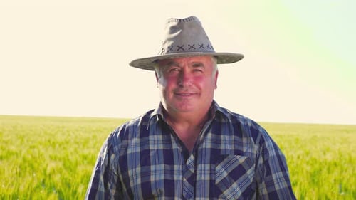 Smiling Farmer Standing in Green Field