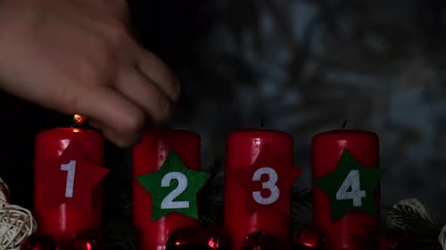 Vier rote Adventskerzen mit Zahlen, brennenden Tannenzweigen und weihnachtlichen Zero Waste-Dekorationen in