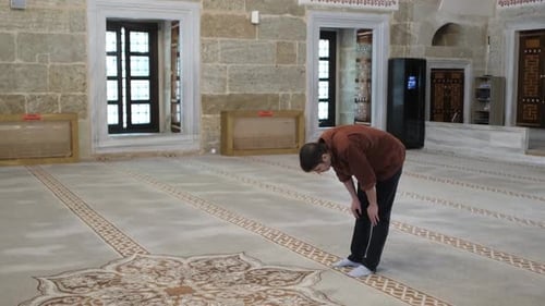 Young Adult Praying Barefoot in Mosque