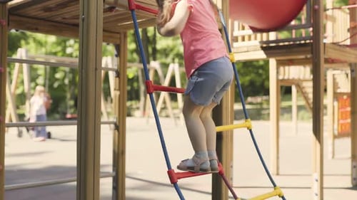Playful Girl Climbing and Playing on the Outdoor Playground