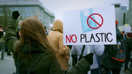 Une femme tient une bannière de protestation écologique Démonstration écologique sans plaque en plastique