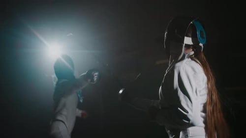 Swordswoman Attacking Her Opponent with Foil Sword During Competition