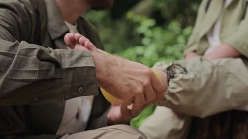 Adult Wrapping Foot of Child in Nature