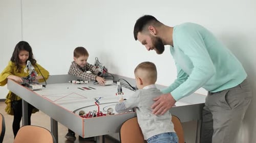 Man and Children Play in a Robotics School